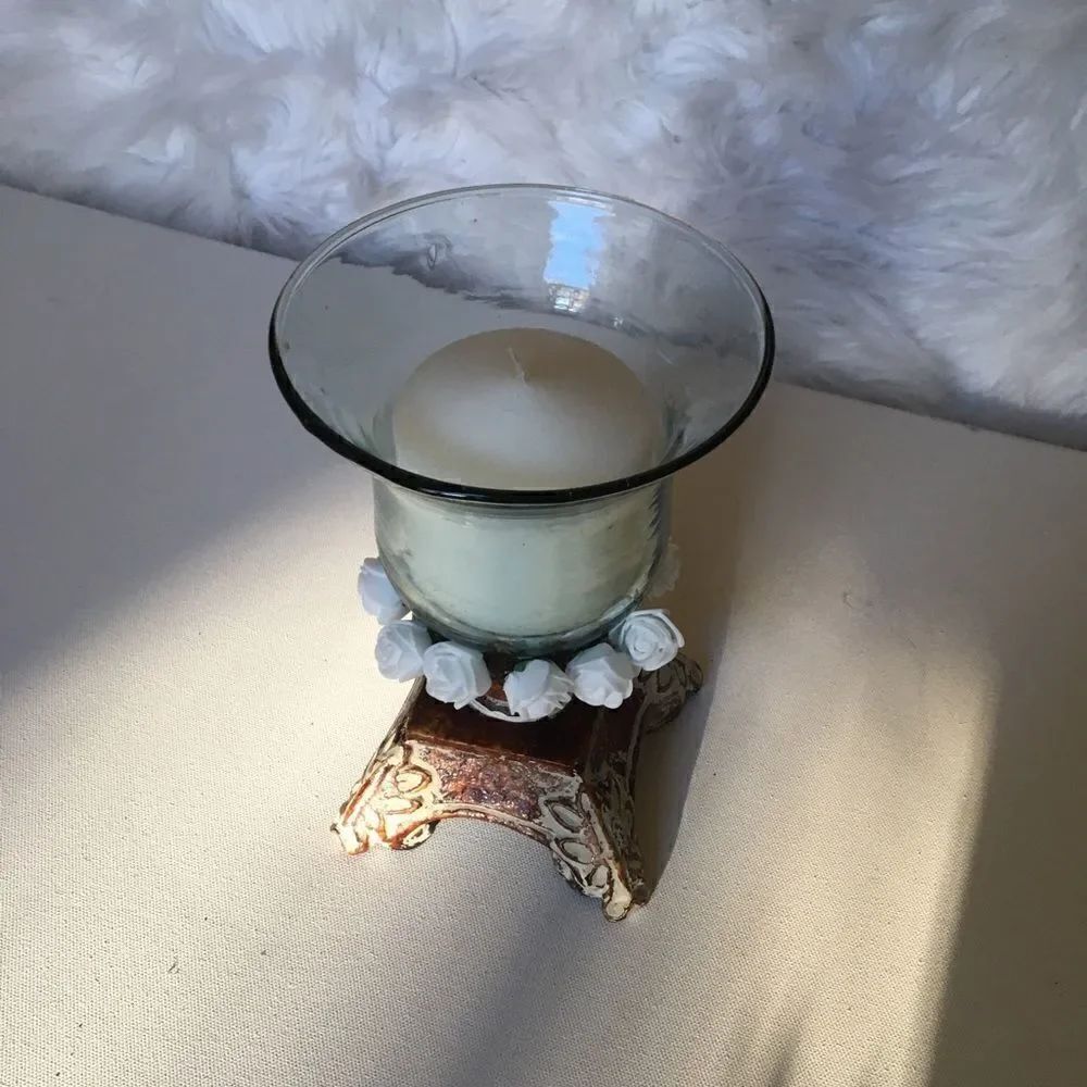 Glass candle holder sitting  on a pedestal